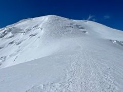 03B The ridge climbs gently to the steep face of Razdelnaya Peak on the way to Ak-Sai Travel Lenin Peak Camp 3 6100m